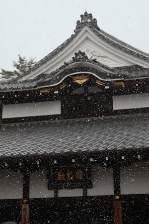 Traditional Japanese architecture under winter snowfall