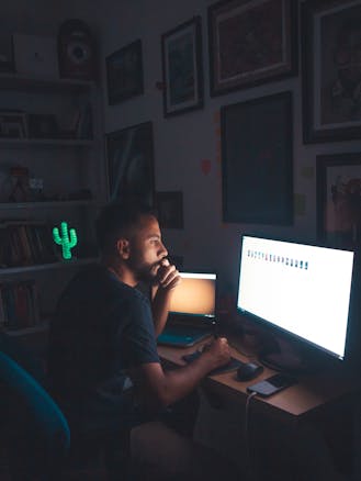 Person reviewing images on a computer screen in a dark room