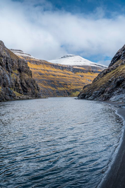 Scenic winter landscape of the Faroe Islands with fog rolling over dramatic cliffs and green hills
